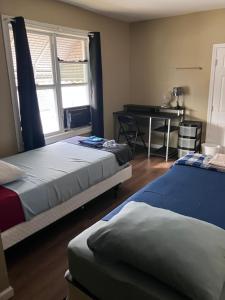 two beds in a room with a desk and a table at Revelation Home in Chicago