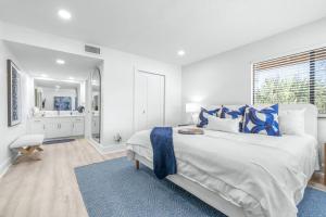 a white bedroom with a large bed and a bathroom at Golf Coast Bleu II - 3158 in Zephyrhills