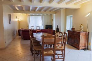 a dining room and living room with a table and chairs at L'Ancien Relais in Genouilly