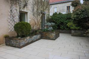 a courtyard with two planters on the side of a house at L'Ancien Relais in Genouilly