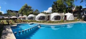 a large swimming pool with domes and a resort at Glamping en Valle de Bravo in Valle de Bravo