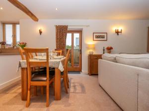 a kitchen and living room with a table and a couch at Grange Cottage in Crediton