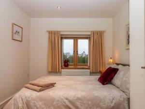 a bedroom with a bed and a window at Grange Cottage in Crediton