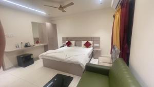 a small bedroom with a bed and a couch at Sithara Grand in Ongole