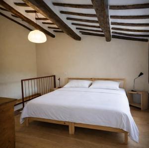 a bedroom with a large bed with white sheets at Ostello Bello Assisi Bevagna in Bevagna