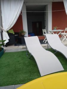 a patio with green grass and white chairs at la terrazza relax in Corniglia