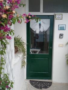 a green door on the side of a house with flowers at la terrazza relax in Corniglia