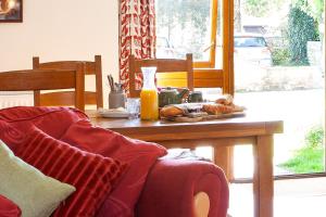 a living room with a wooden table with a couch at Pintle Cottage in Charlbury