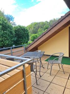 eine Terrasse mit Tisch und Stühlen auf einem Dach in der Unterkunft Wohnung Widdern in Widdern