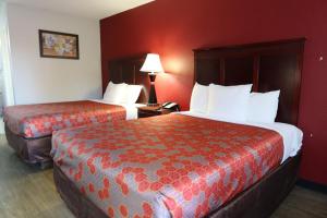 two beds in a hotel room with red walls at Econo Lodge Inn & Suites Evergreen in Evergreen