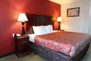 a hotel room with a bed and two lamps at Econo Lodge Inn & Suites Evergreen in Evergreen