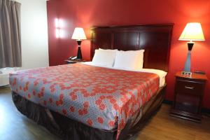 a hotel room with a large bed with red walls at Econo Lodge Inn & Suites Evergreen in Evergreen