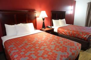 two beds in a hotel room with red walls at Econo Lodge Inn & Suites Evergreen in Evergreen
