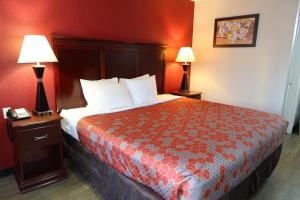 a hotel room with a large bed with two lamps at Econo Lodge Inn & Suites Evergreen in Evergreen +4 photos