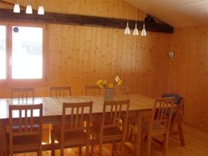 a dining room with a large wooden table and chairs at Grand chalet en Gruyère in Sorens