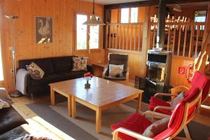 a living room with a coffee table and a fireplace at Grand chalet en Gruyère in Sorens