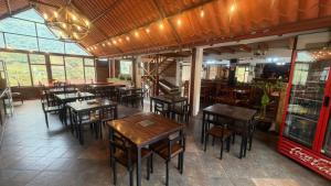 a restaurant with wooden tables and chairs and windows at Hostería Agoyan Deluxe in Ulba