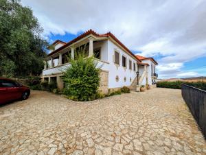 a house with a car parked in the driveway at Casas Telhadas in Trancoso