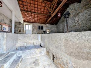 a stone room with a stone wall and stairs at Casas Telhadas in Trancoso +34 photos
