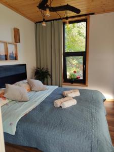 a bedroom with a large bed with towels on it at Domek Ponad Mgłami in Laskowa