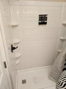 a bathroom with a shower with a white tiled shower at Apartment in Cleveland in Cleveland