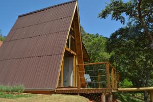 a frame cabin with a pitched roof and a porch at Chalé Pé da Serra - Região de Monte Verde in Camanducaia