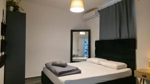 a bedroom with a bed with a mirror on it at BOND Grand Suites in Beer Sheva
