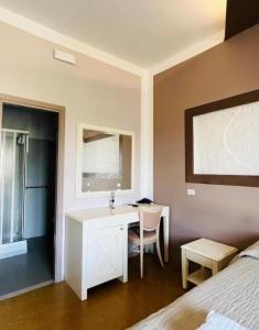 ein Badezimmer mit Waschbecken und Schreibtisch in einem Zimmer in der Unterkunft Due Portoni in Castel San Pietro Terme