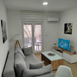 a living room with a couch and a table at Cera luxe apartment in Soko Banja