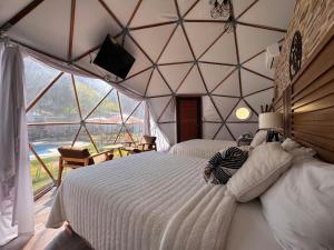 a person laying on a bed in a room with a window at Glamping en Valle de Bravo in Valle de Bravo
