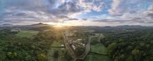 an aerial view of a forest with the sun setting at Tiny Homes Tamarindo in Tamarindo +3 photos