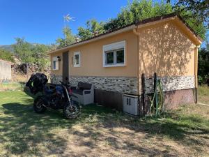 a motorcycle parked in front of a small house at La casita in Pinilla del Valle