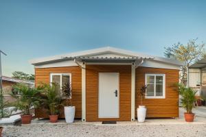 a small wooden house with a white door at Tiny Homes Tamarindo in Tamarindo