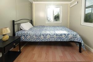 a bedroom with a bed with a blue and white blanket at Tiny Homes Tamarindo in Tamarindo