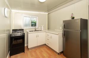 a kitchen with a stainless steel refrigerator and white cabinets at Tiny Homes Tamarindo in Tamarindo