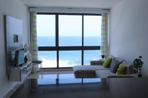 ein Wohnzimmer mit Sofa und großem Fenster in der Unterkunft Casa Nova in Ribeira Grande