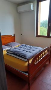 a bed with a wooden frame in a room with a window at Bel Appartement Fonctionnel,2 grandes chambres separer plus un bz,WI FI,Clim in Digoin