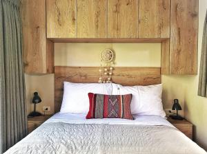 a bedroom with a large bed with a wooden headboard at Tiny Mountain River in Urubamba