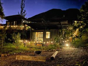 a house with lights in the yard at night at Tiny Mountain River in Urubamba