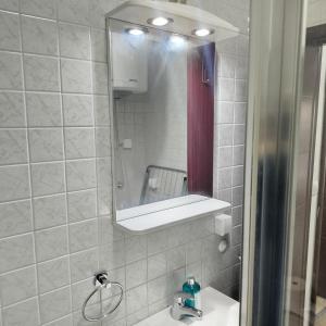 a bathroom with a mirror and a white sink at Cera luxe apartment in Soko Banja