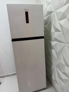 a white refrigerator in a room with a wall at Lua prime residence in Petrolina