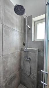 a shower with a shower head in a bathroom at Plaka View Nest in Plaka Milou