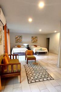 a hotel room with two beds and a living room at Hotel Plaza Yara in Manuel Antonio