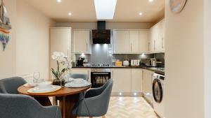 a kitchen with a table and chairs and a kitchen with white cabinets at Creel Cottage, Lower Largo in Lower Largo
