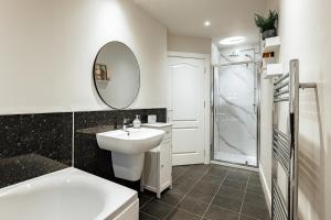 a white bathroom with a sink and a mirror at Creel Cottage, Lower Largo in Lower Largo +14 photos