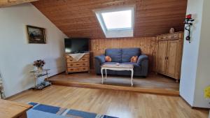 a living room with a blue couch and a television at Ferienwohnung am Marienbrunnen in Bad Bayersoien