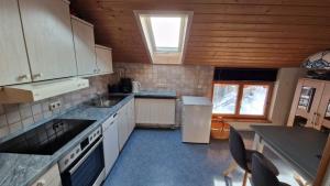 a kitchen with white appliances and a wooden ceiling at Ferienwohnung am Marienbrunnen in Bad Bayersoien