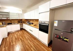 a kitchen with white cabinets and a stainless steel refrigerator at Guest house in Addis Ababa