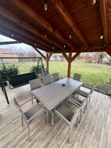 a wooden table and chairs on a wooden deck at Napfény Apartman in Makó