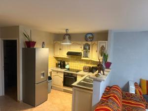 a kitchen with a refrigerator and a sink at Charmante maison au calme in Sainte-Maure